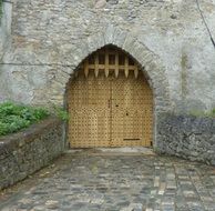 closed gates with grate in medieval stone wall