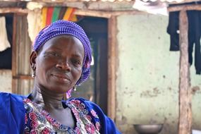 smiling african woman at hut, portrait
