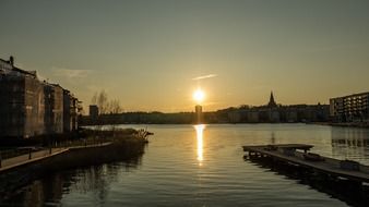 sunset above town at water