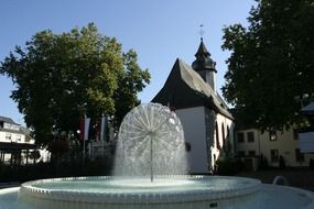 modern fountain in park at old chapel