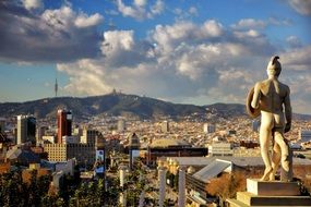 ancient statue above city, spain, barcelona