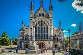 people resting at winchester cathedral, uk, england