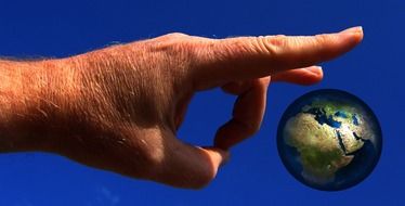 male hand flicking earth globe, collage
