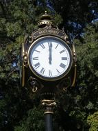 antique street clock at green foliage in Bucharest, Romani