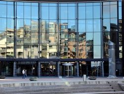 mirroring of building on glass facade, norway, oslo, aker brygge