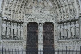 Ornamental gothic stone saints statues on facade at doors of Notre-Dame cathedral, france, paris