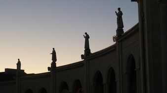 statues silhouette on roof of Sanctuary of Our Lady of Fátima at dusk, portugal, Ourém