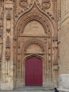 closed red door of cothic church, spain, salamanca