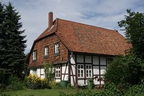 traditional truss house with clay tile roof in garden, germany, edemissen