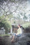 woman sitting on the stones in garden