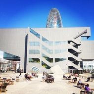 people resting at tables near Torre Glories, spain, barcelona