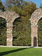 Ancient roman brick wall in green leaves