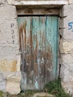 weathered wooden door in stone facade