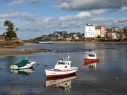 anchored boats on water in view of coastal town