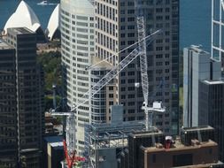 cranes on construction site in city at opera house, australia, sidney