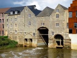 row of old buildings across waterflow, belgium, aarschot