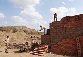 workers laying bricks at countryside, india, dharwad