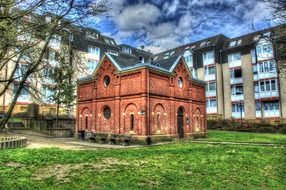 old red brick building in yard of modern apartments, germany