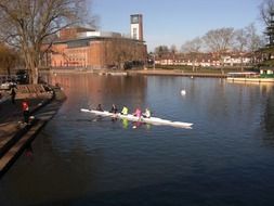 people in rowing boat on calm water in city park