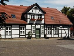 truss building with windows on red tile roof, germany