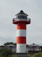 lighthouse with red white strips at village