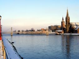 winter landscape with river, bridge and church