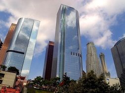 skyscrapers in city, low angle view with white clouds in blue sky, usa, california, los angeles