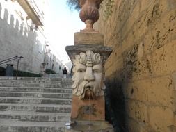 ancient fountain with stone carved face at stairs outdoor, spain, majorca