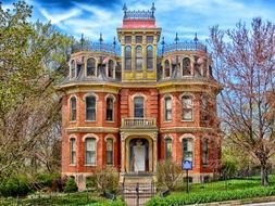 victorian mansion with towers in garden, usa, iowa, davenport