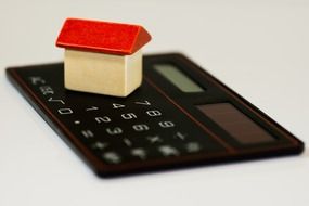 Brick toy house on home calculator