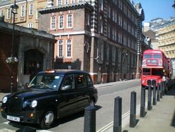 black taxi and red double-decker bus on old street, uk, england, london