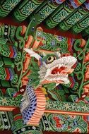 carved horned dragon head at roof of temple, korea