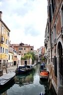 motor boats parked on channel at grunge houses, italy, venice