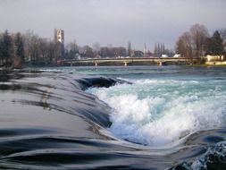 distant bridge across foaming water flow, bosnia, bihac