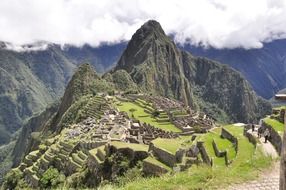 ancient ruins of machu picchu on mountain under clouds, peru, andes