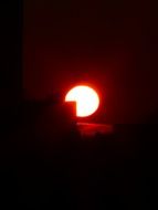 sun fireball behind building in darkness