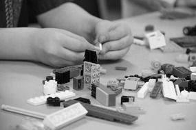 black and white photo lego toy pieces construction playing child