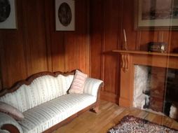 sofa at fireplace in living room, vintage interior