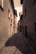 perspective of long alley in old town in italy