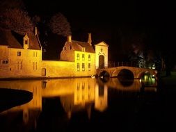 old town mirroring on water at night, belgium, bruges