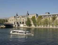 excursion boat on seine river at louvre near the bridge, france, paris