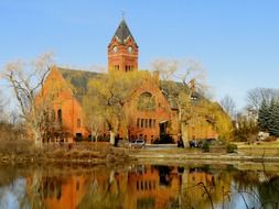 town hall mirroring on water at fall, usa, massachusetts, winchester