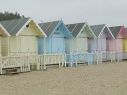 row of colorful beach huts on the sandy coast