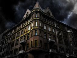 haunted house, old corner building at dark clouds