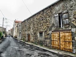 old wildstone buildings along empty street in france, puy de dome