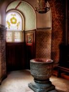 aged stone carved vase at stained glass window in church, denmark, copenhagen