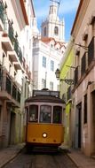 yellow tram in alley of old town, portugal, lisbon