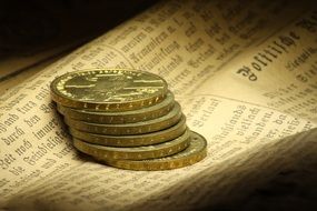 pile of coins on old german newspaper