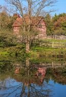 old village building mirroring on water at fall