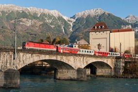 train on bridge above river at mountains, austria